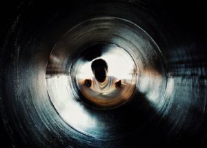 Person looking through pipe