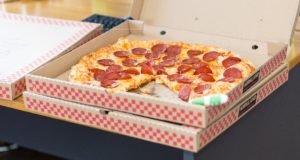 Pizza boxes, top one with lid open showing pepperoni pizza